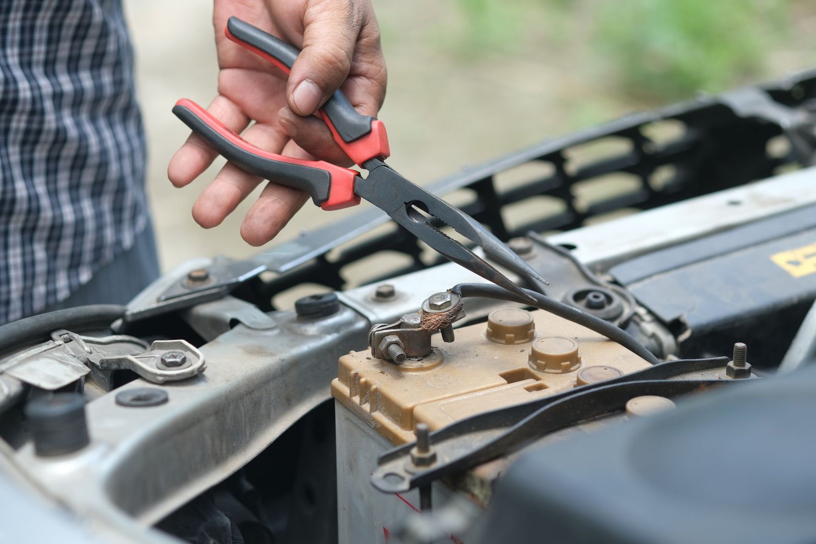 Replacing a car battery with a socket wrench